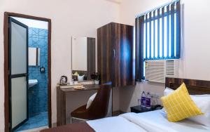 a bedroom with a bed and a desk and a mirror at Sukoon Pearl inn in Jabalpur