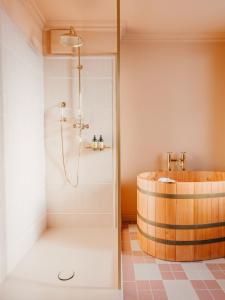 a bathroom with a shower and a wooden tub at BEAUSiTE Zermatt in Zermatt
