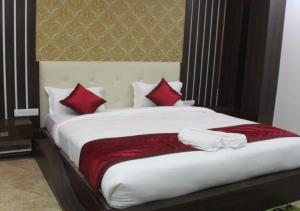 a bedroom with a large bed with red pillows at HOTEL GOLDEN TULIP in Pūrnia