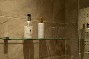 two bottles of wine sitting on a glass shelf in a bathroom at Deanfield in Parkend +55 photos