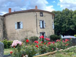 an old building with flowers in front of it at Tour du Château de Gondole in Le Cendre