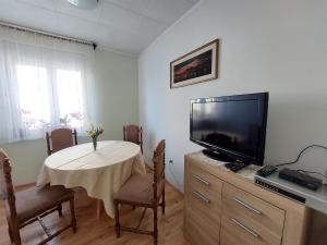 a living room with a table with a tv and a table sidx sidx at Apartment KRUNO in Selce