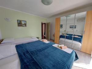 a bedroom with a large blue bed and a mirror at Apartment KRUNO in Selce