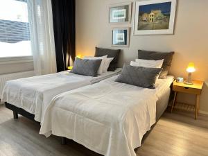 - 2 lits dans une chambre d'hôtel avec des draps blancs dans l'établissement Time Apartments Kärpänkuja, à Jyväskylä