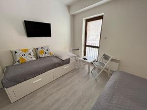 a bedroom with a bed and a tv on the wall at Garni pension U svatého Urbana in Mikulov