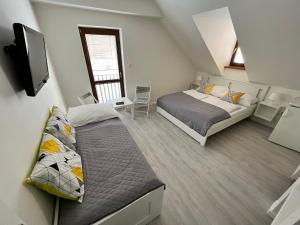 a bedroom with two beds and a tv in it at Garni pension U svatého Urbana in Mikulov