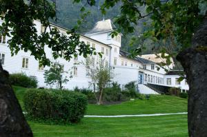 a large white building with a grass yard at Fretheim Hotel in Flåm