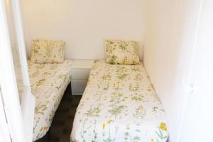 リョレート・デ・マルにあるLloret Centre Apartmentの花の咲く小さな部屋のベッド2台