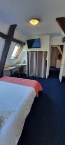 アルグルにあるAuberge du Gros Tilleulのベッドとデスクが備わるホテルルームです。