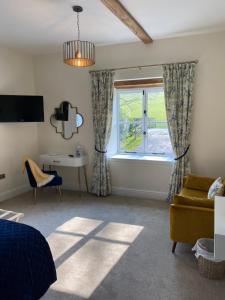 a bedroom with a bed and a desk and a window at Black Mountain Lodge in Glasbury