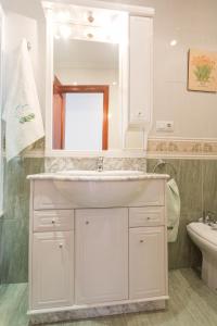 Baño blanco con lavabo y espejo en Casa Goros II, en Melide