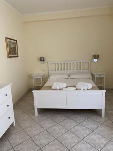 a bedroom with a white bed with two pillows on it at Casa Tacconi in Villasimius