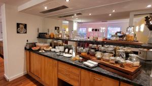 a kitchen with a counter filled with lots of food at Tulip Inn Frankfurt Airport in Neu Isenburg