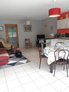 a kitchen with a table and chairs in a room at Gîte AUX 3 PTITS COCHONS in Cuisiat