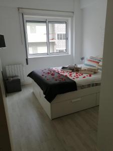 a bedroom with a bed with red flowers on it at Home Beach in Figueira da Foz