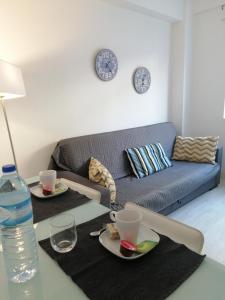 a living room with a couch and a table with plates and drinks at Home Beach in Figueira da Foz