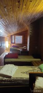 a room with four beds and a wooden ceiling at Aghrougolok Hostel in Lida