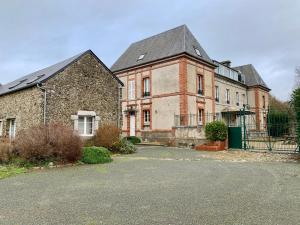 un gran edificio de ladrillo con una puerta delante en Gîtes grands groupes - Château des Forges Gouville en Gouville-sur-Mer