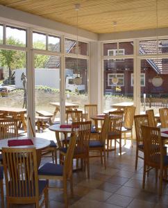 restauracja ze stołami, krzesłami i oknami w obiekcie Aika w mieście Nida