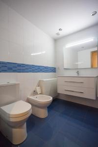 a bathroom with two toilets and a sink and a mirror at Casa Goros in Melide