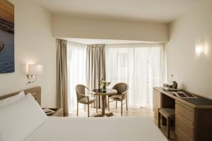 a hotel room with a bed and a table with chairs at The Diplomat Hotel in Sliema