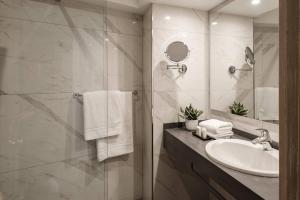 a bathroom with a sink and a shower at The Diplomat Hotel in Sliema