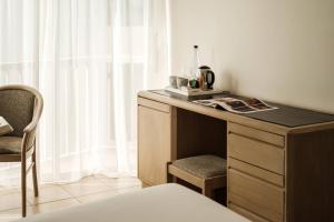 a desk with a chair next to a window at The Diplomat Hotel in Sliema