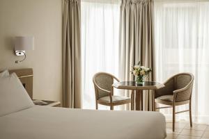 a hotel room with a bed and a table and chairs at The Diplomat Hotel in Sliema
