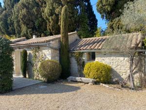 een stenen huis met een boom ervoor bij Mas des Bambous in Saint-Rémy-de-Provence