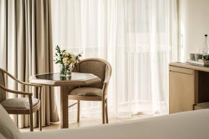 a room with a table and two chairs and a window at The Diplomat Hotel in Sliema
