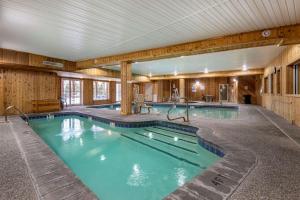 a swimming pool in a large room with wooden walls at Mountain Edge Suites at Sunapee, Ascend Hotel Collection in Newbury