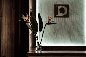 a vase with flowers on a table next to a window at The Diplomat Hotel in Sliema