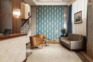 a lobby with two chairs and a couch and a table at The Diplomat Hotel in Sliema
