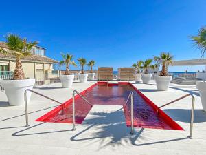 una piscina con due sedie e palme di AMAZING SEA VIEWS - The Wave, Brand new apartment a Fuengirola