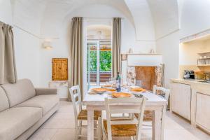 a kitchen and living room with a table and chairs at La Torretta Suite - Raro Rooms Collection in Ostuni