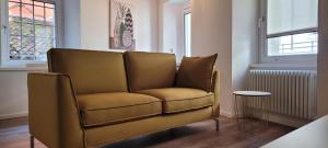 a brown couch in a room with a window at Sarpi21 Suites in Udine