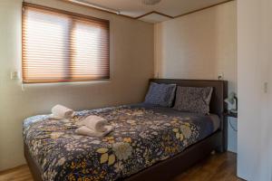 un dormitorio con una cama con dos animales de peluche en Drents Genieten - Riegheide met privé jacuzzi, en Erm