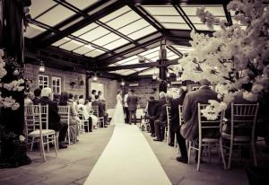 a bride and groom walking down the aisle at a wedding at Santo's Higham Farm Hotel in Alfreton