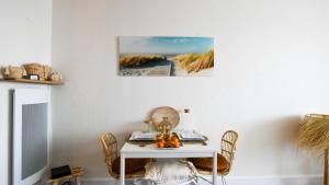 mesa con sillas y mesa blanca con espejo en Studio Le Surfing de Carnon plage, en Carnon-Plage