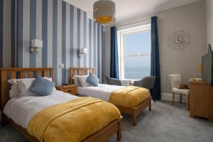 a hotel room with two beds and a window at The Kendrick Exclusively for adults in Llandudno