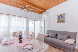 a dining room with a table and a couch at Apartments Zora in Starigrad-Paklenica