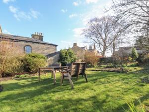 a table and bench in the grass in a yard at Windyridge in Settle