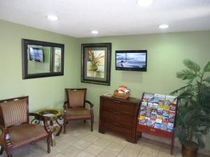 a waiting room with two chairs and a desk and a tv at TownHouse Extended Stay Hotel Downtown in Lincoln