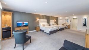 a hotel room with two beds and a flat screen tv at The Barnstaple Hotel in Barnstaple