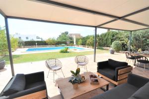 patio z kanapami, stołem i krzesłami w obiekcie Hermosa casa de vacaciones CA NA MALEN w mieście La Cabaneta