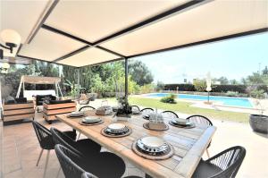 stół z krzesłami i duży parasol na świeżym powietrzu w obiekcie Hermosa casa de vacaciones CA NA MALEN w mieście La Cabaneta