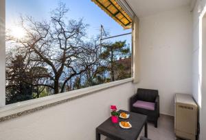a balcony with a table and a chair and a window at Apartman Jasmina 2 in Rijeka