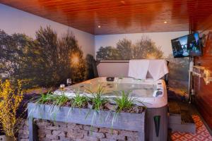 baño con bañera con plantas. en Drents Genieten - Dopheide met privé jacuzzi en sauna, en Erm