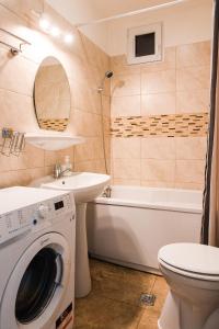 a bathroom with a washer and a sink and a washing machine at Old Town Cozy Apartment - University Square - Central Location in Bucharest