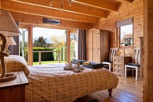 een slaapkamer met een bed in een houten hut bij Finest Retreats - Garden Lodge in Craven Arms